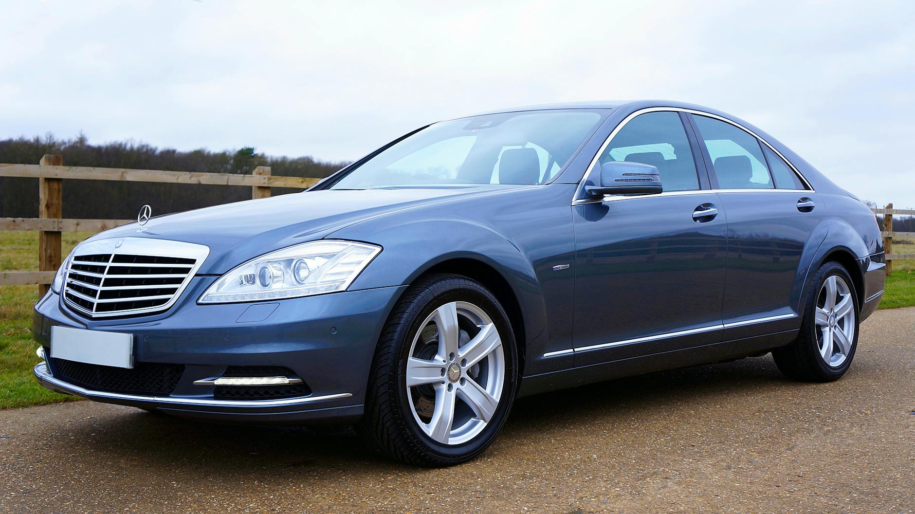 Niebieski sedan Mercedes-Benz zaparkowany na ulicy w Wielkiej Brytanii