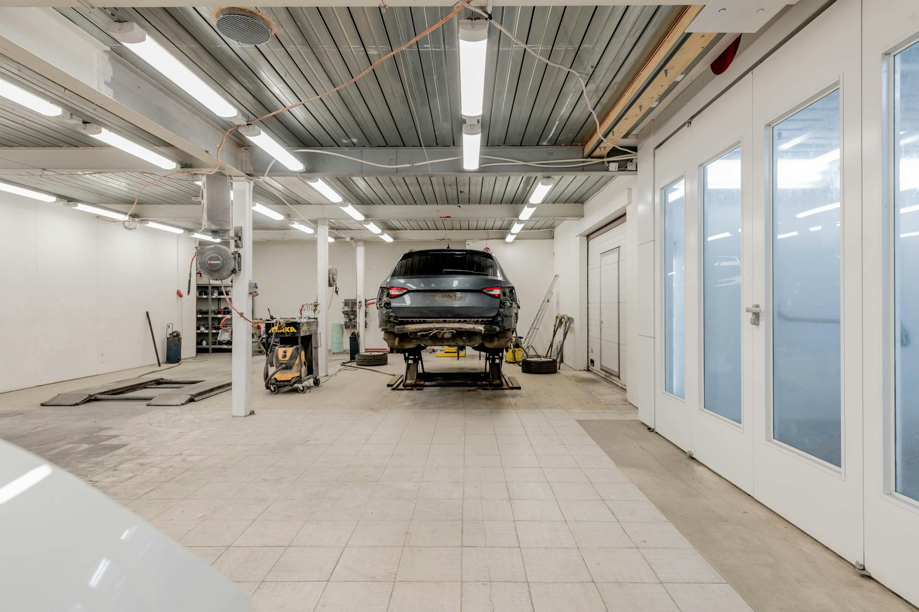 Samochód na podnośniku w dobrze oświetlonym warsztacie samochodowym