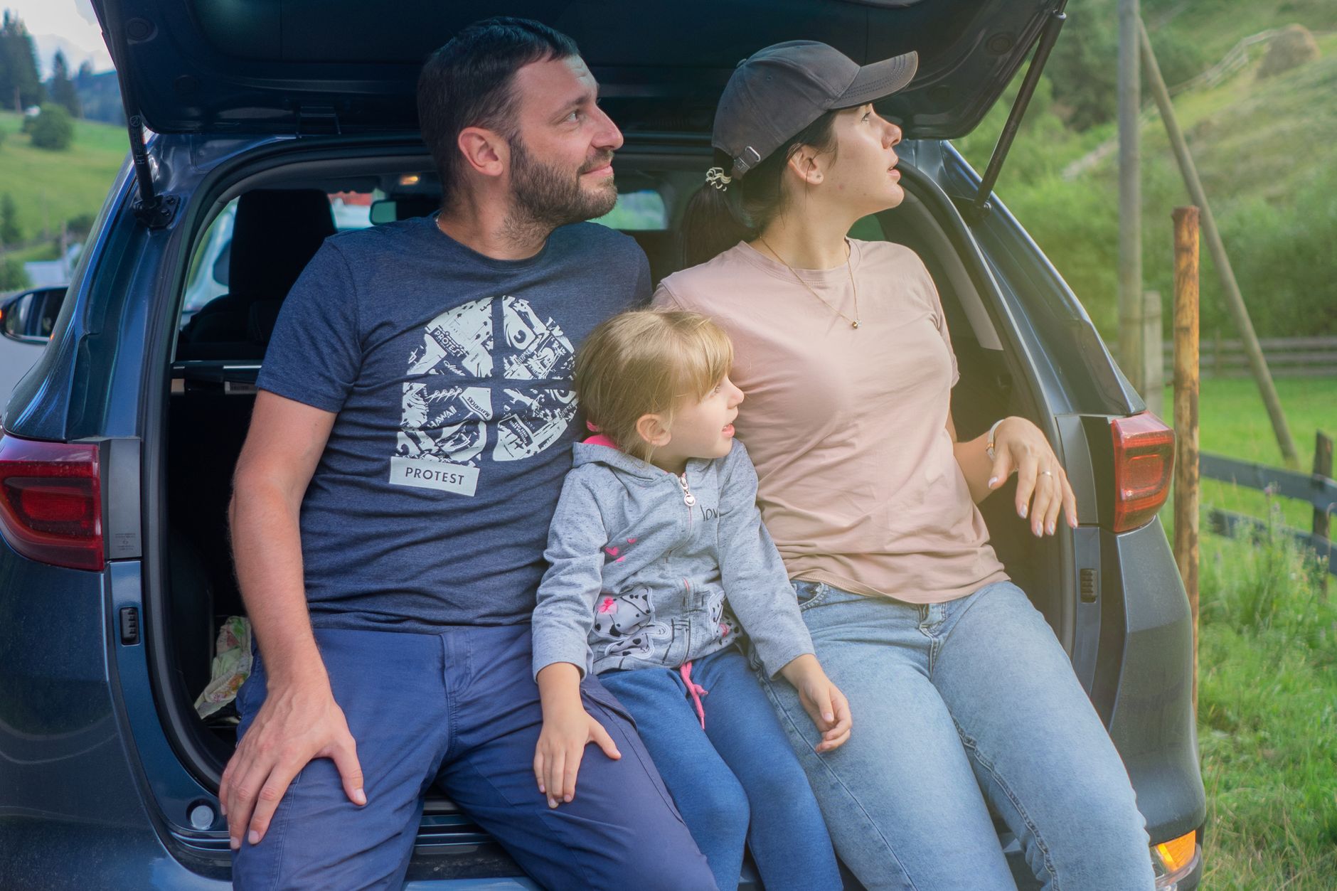 Dacia Jogger kontra kombi z drugiej ręki – co lepiej sprawdzi się jako rodzinny wół roboczy Rodzina siedzi w bagażniku auta podczas wyjazdu za miasto