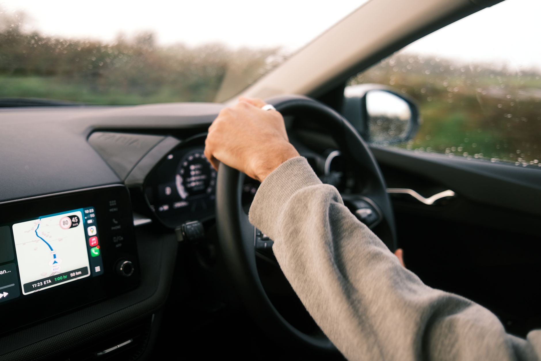 Kierowca w deszczu korzysta z nawigacji GPS na desce rozdzielczej Volvo