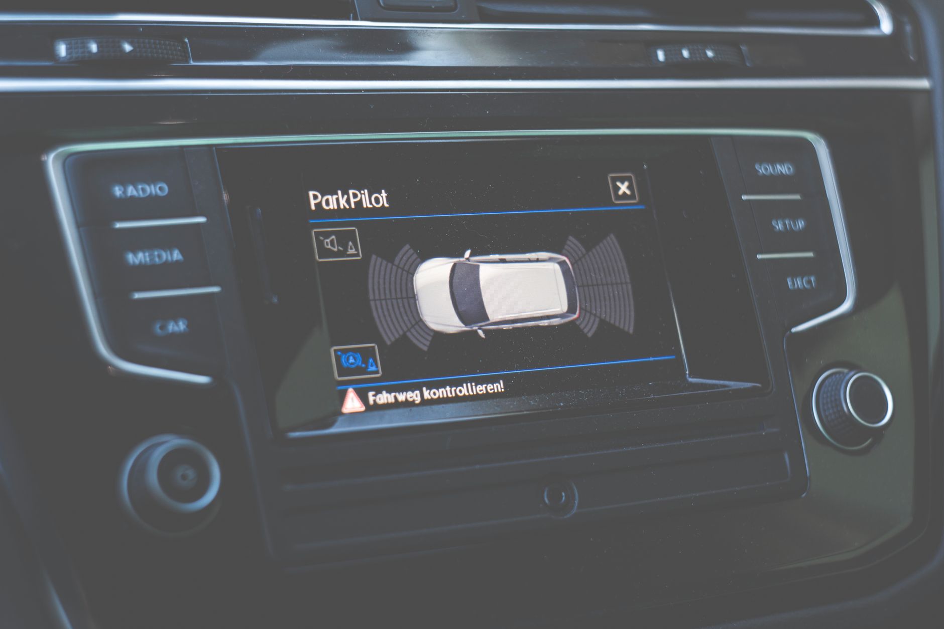 Zbliżenie na deskę rozdzielczą auta z ekranem asystenta ParkPilot